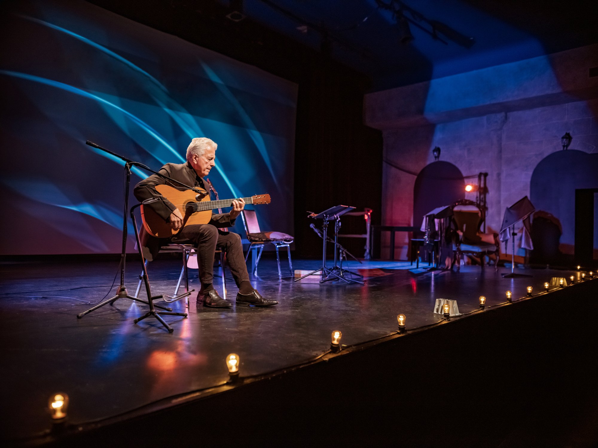 A person playing guitar on stage.