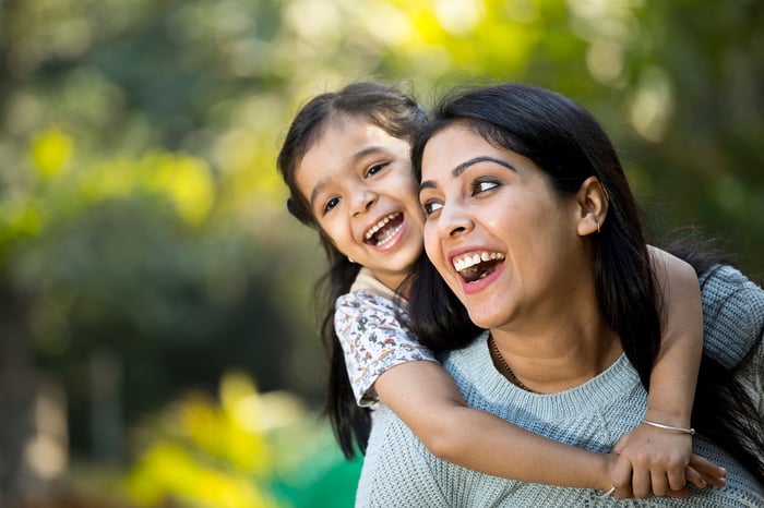 A parent and child have fun in a park.