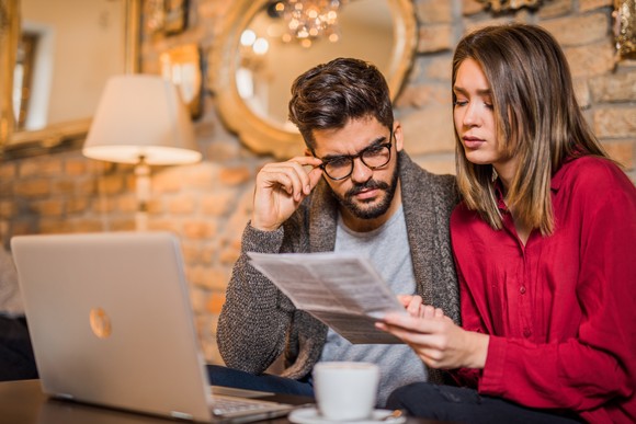 Young couple looking at bills.