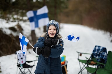 A child with Finland flags on a winter day.