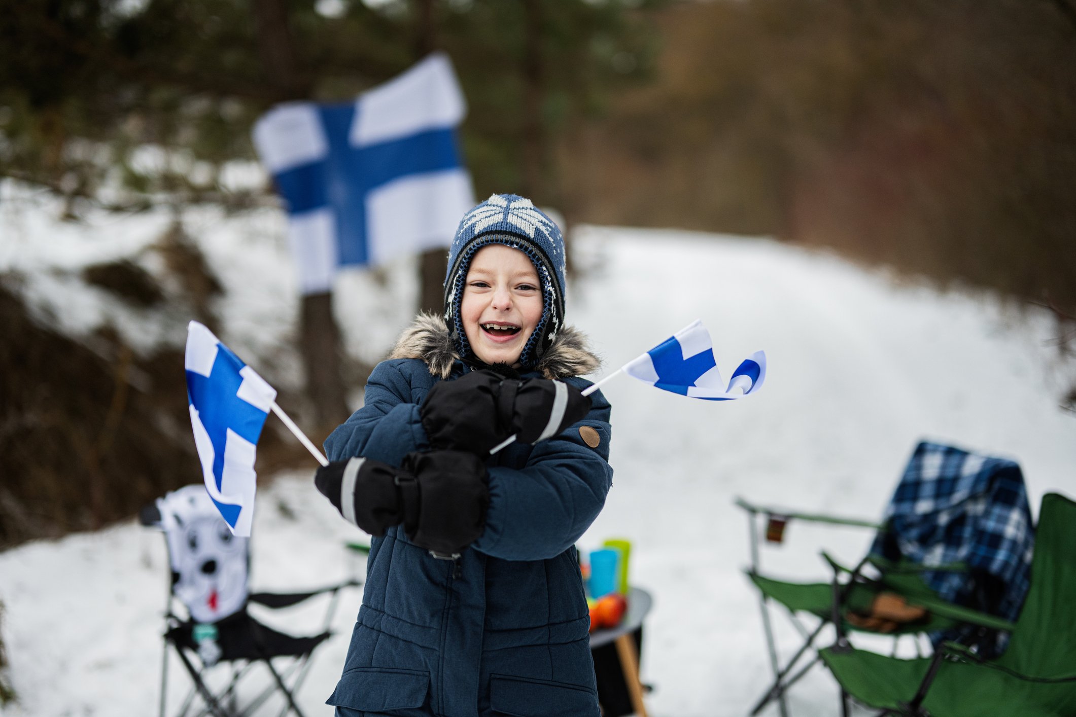 A child with Finland flags on a winter day.