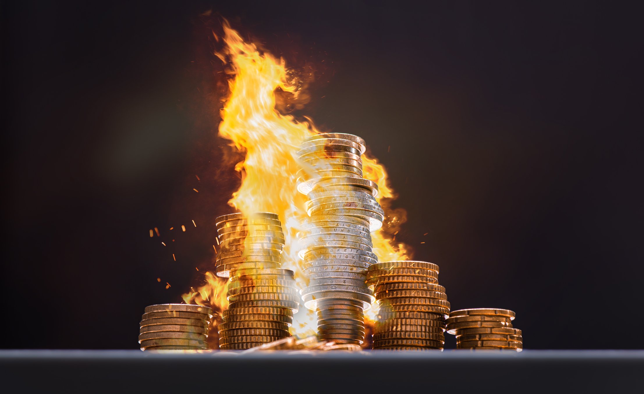 Stack of coins on fire with black background. 
