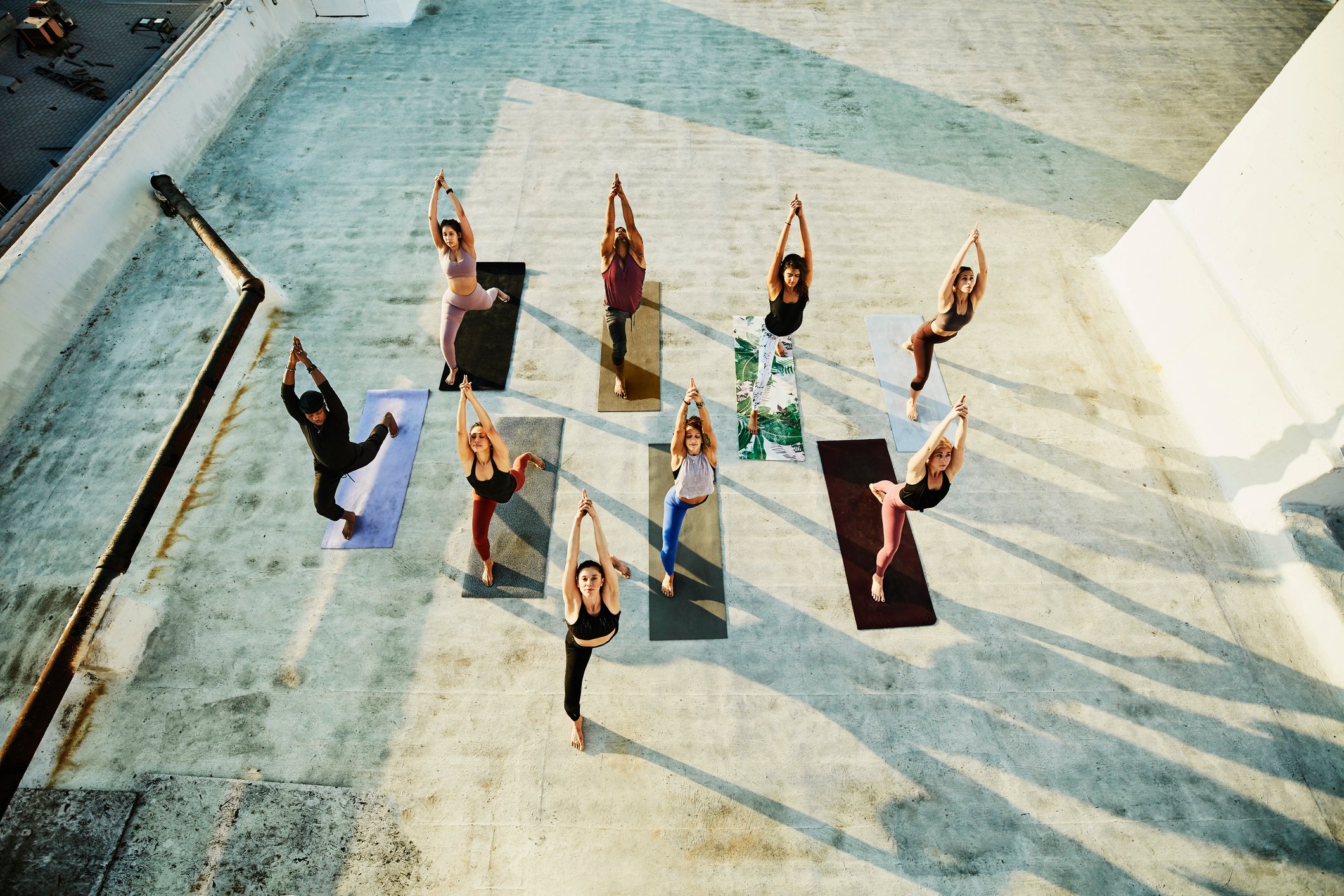 A group of people do yoga on a rooftop.
