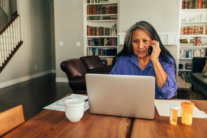 Person on phone at their computer.