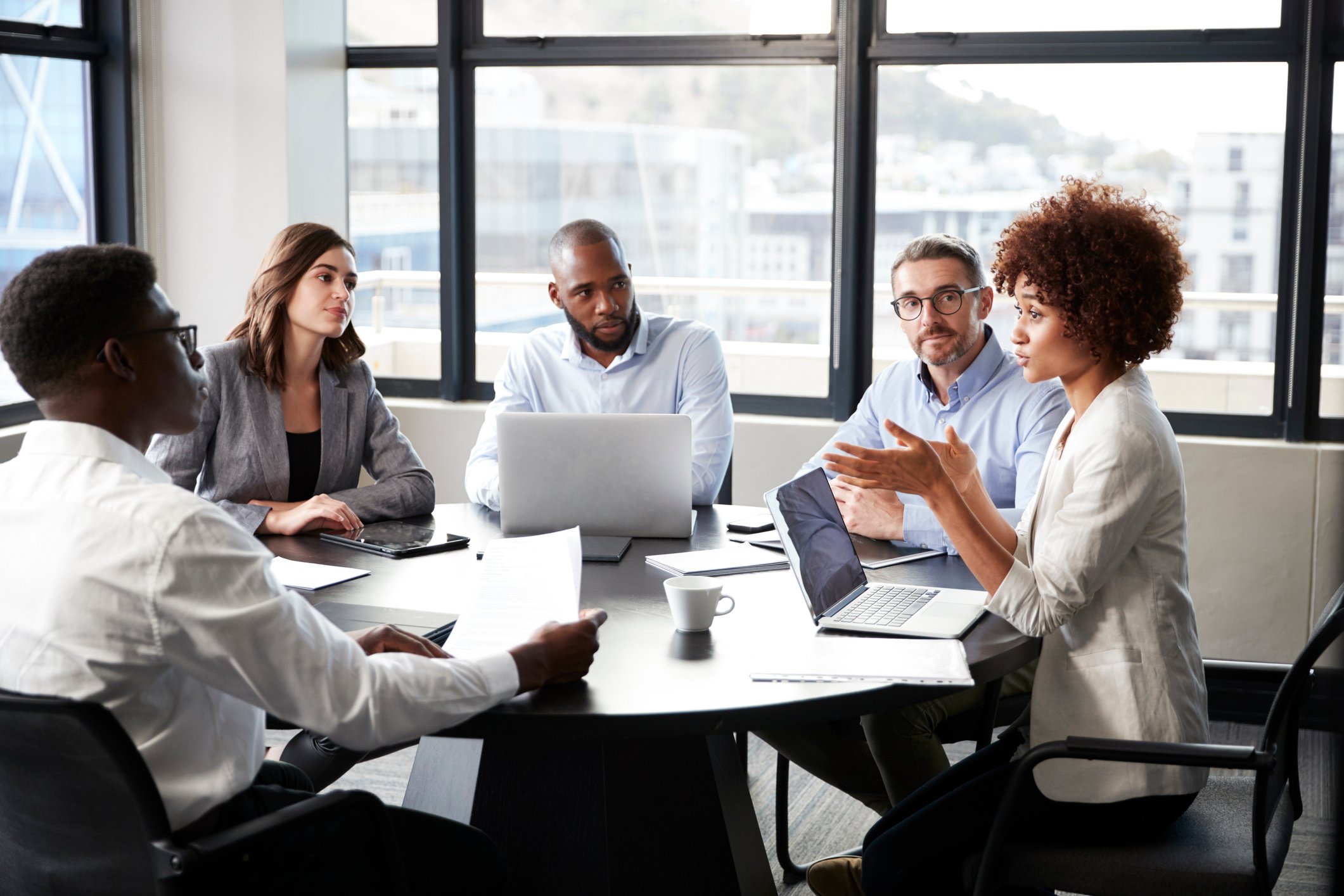 Colleagues seated around a table in a business meeting.