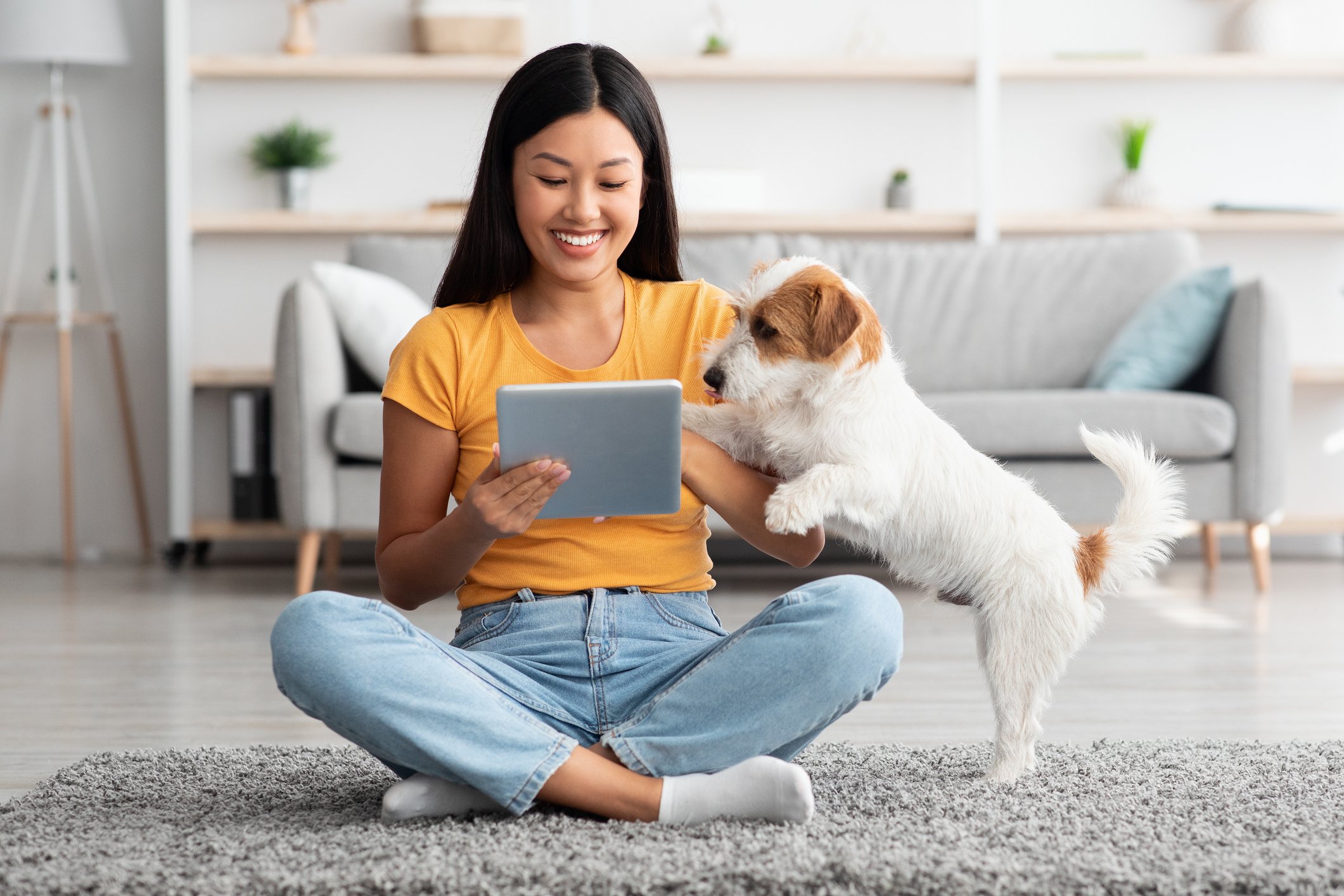 Young woman on tablet with her dog. 