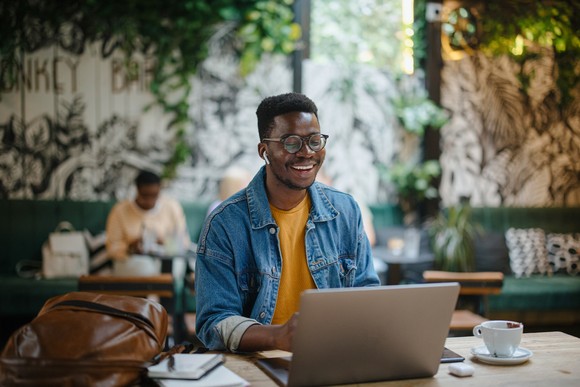 Person smiling at a laptop.