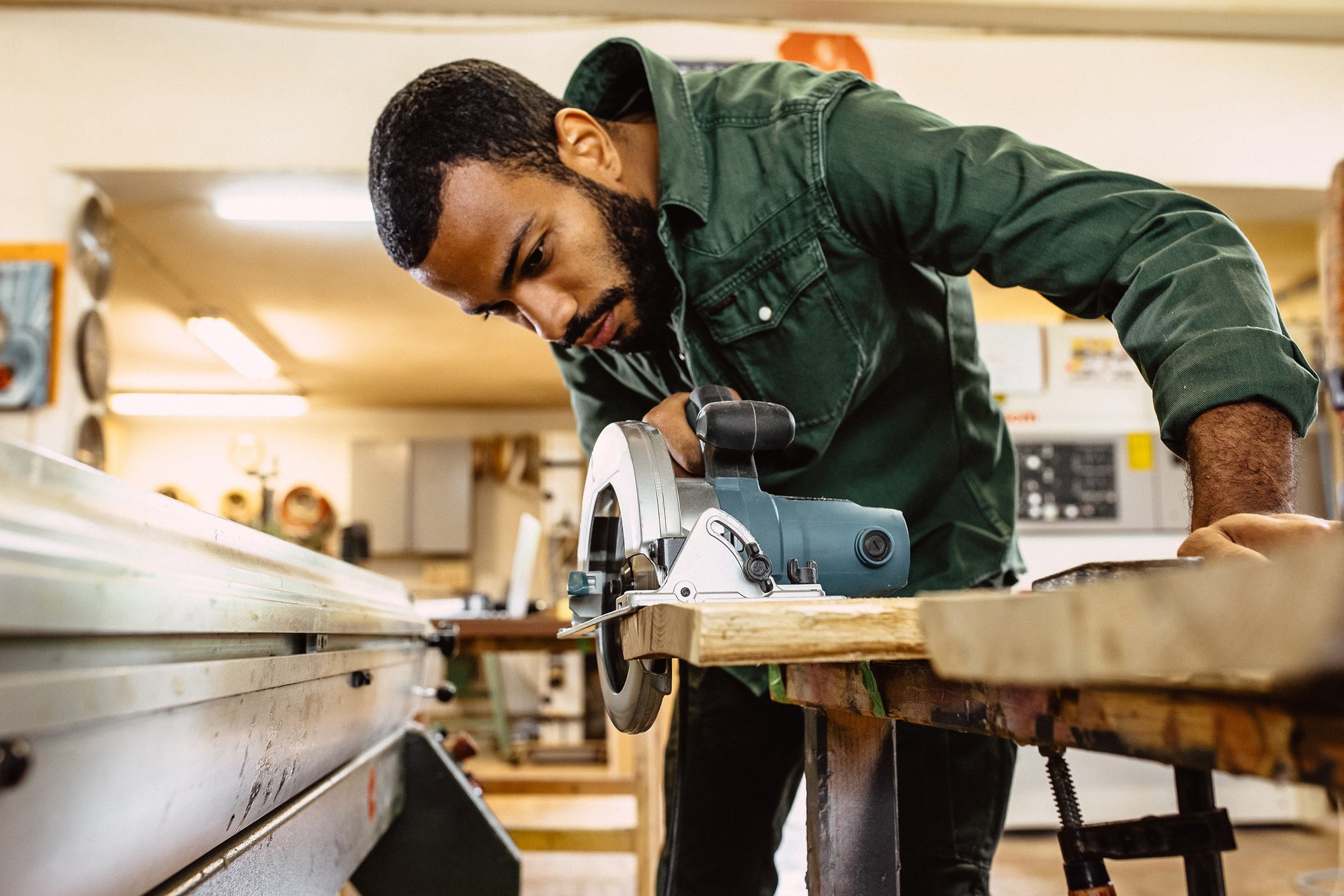 A person uses a circular saw in a house.