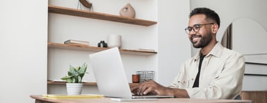 Person on laptop, smiling.