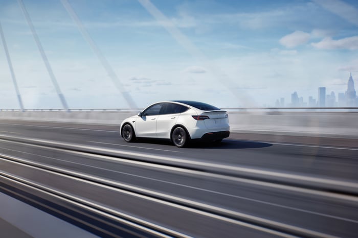  White Tesla Model Y traveling on a highway.