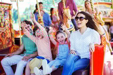 Family on carousel in amusement park