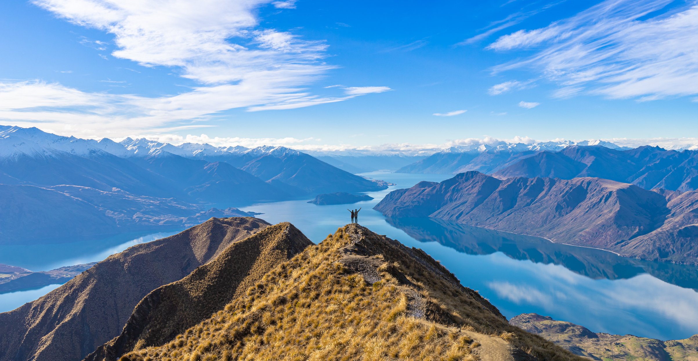 Two people standing on top of a mountain.