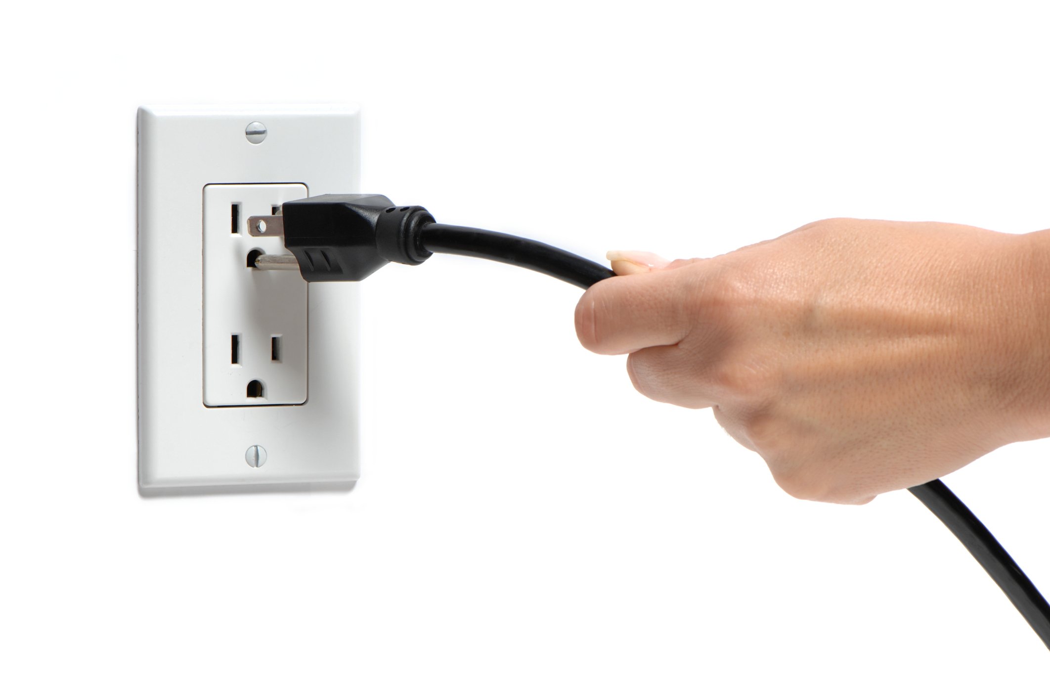 Hand removing a plug from a wall outlet