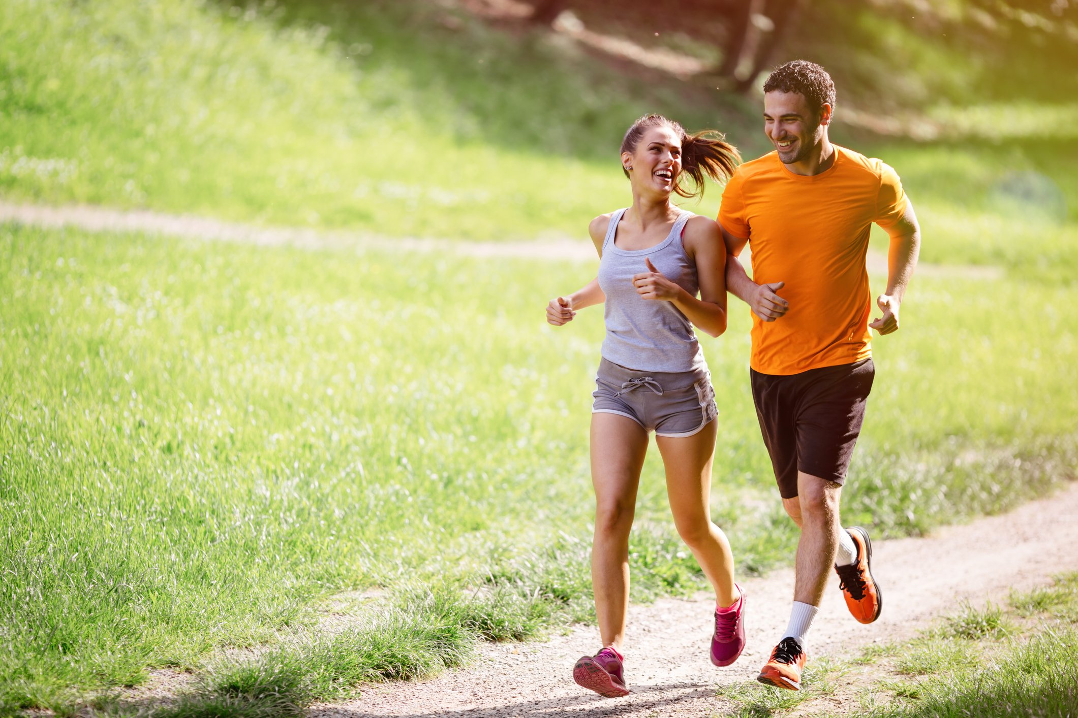 Two people jog outside in nature.
