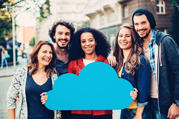 Group of people holding a blue cloud shape.