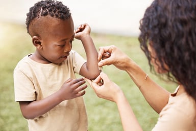 Child getting band-aid put on arm