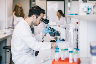Young scientist observing with microscope
