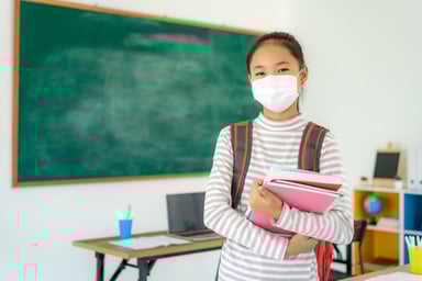 Masked student in a classroom