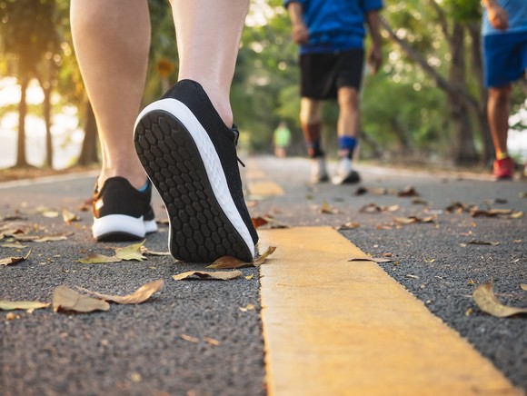 People wearing running shoes on a road.