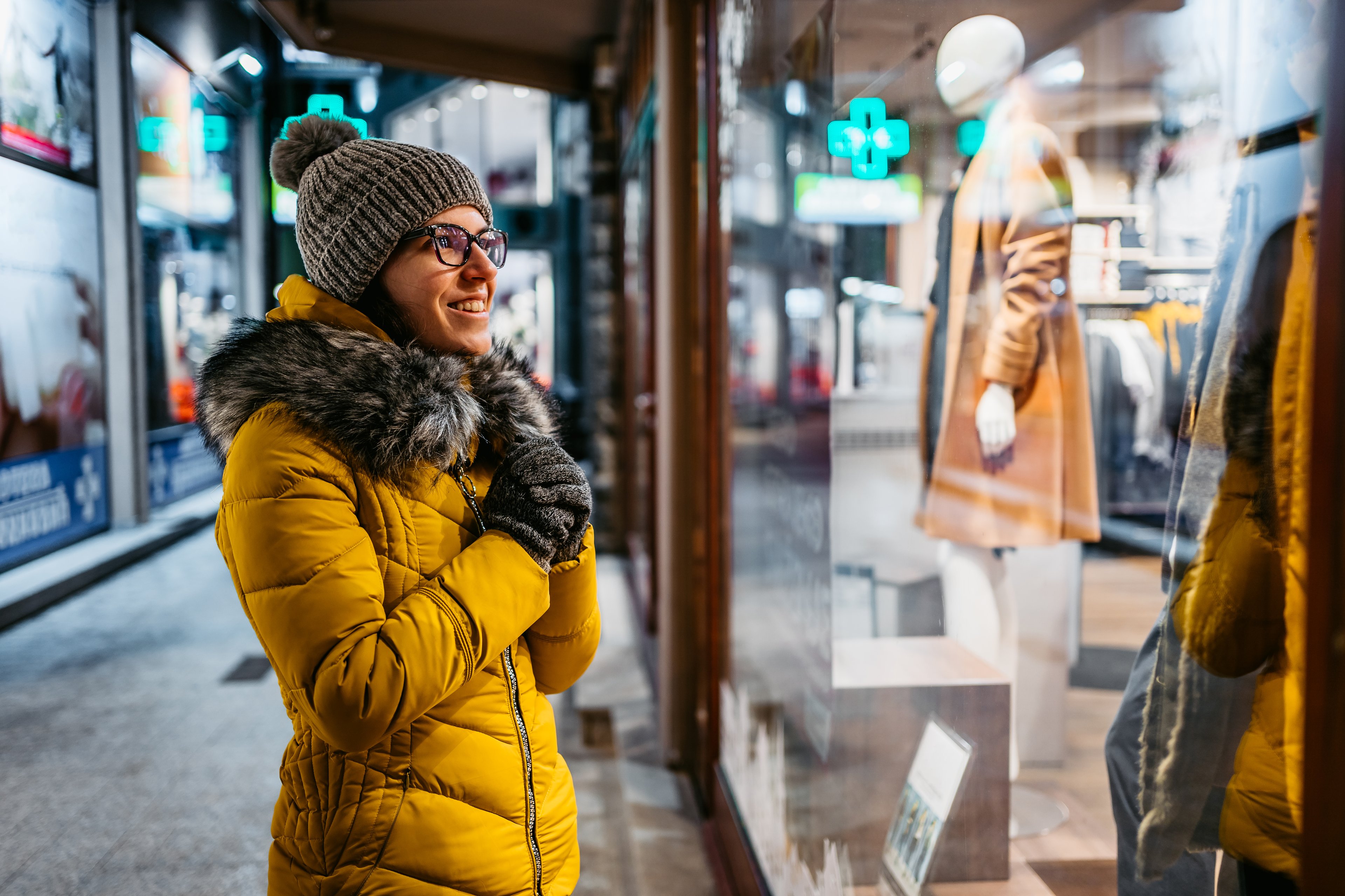 Person in winter coat window-shopping.
