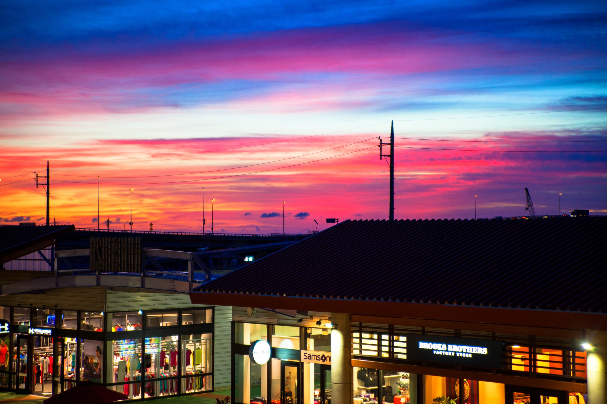 The exterior of an outlet mall at night. 