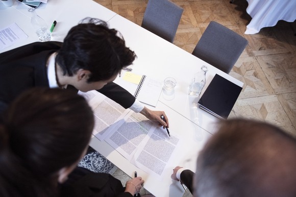 People looking at documents on table.