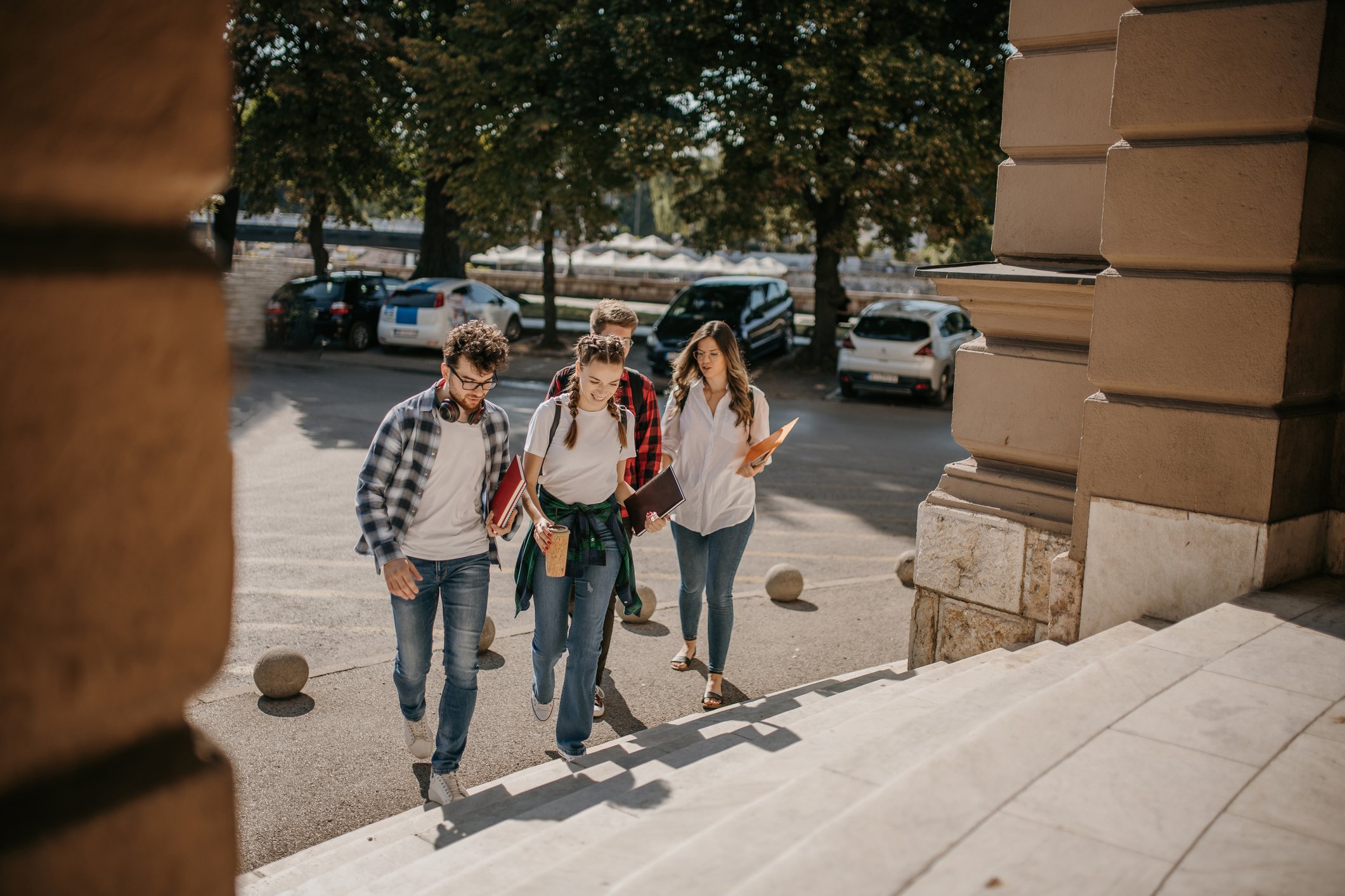 Four people approaching a set of stairs.
