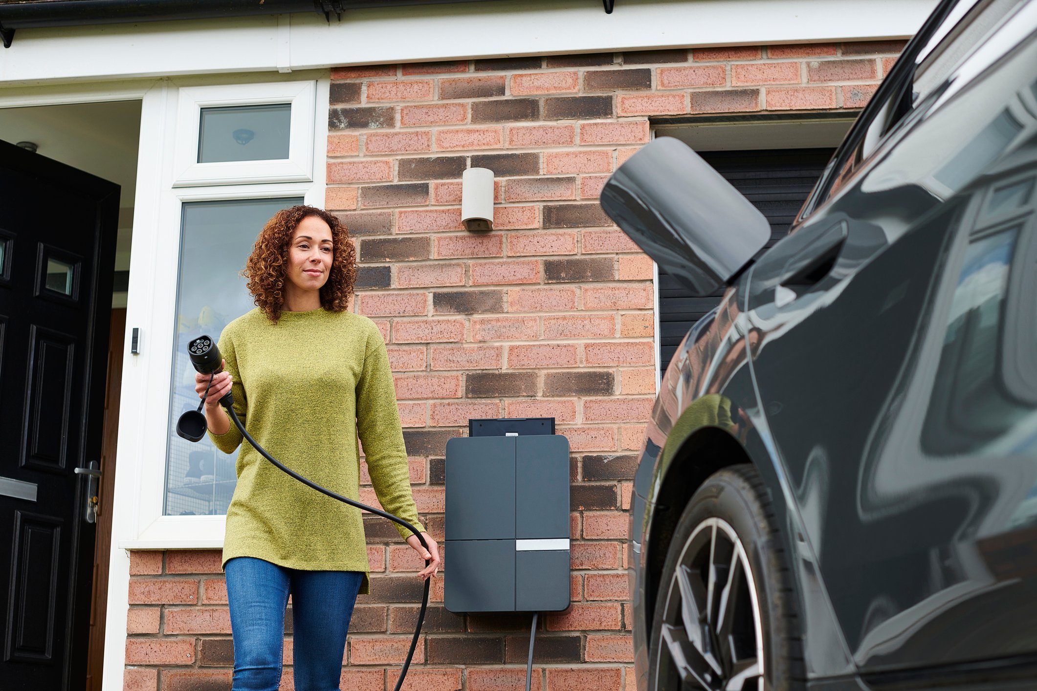 A driver prepares to charge an electric vehicle.