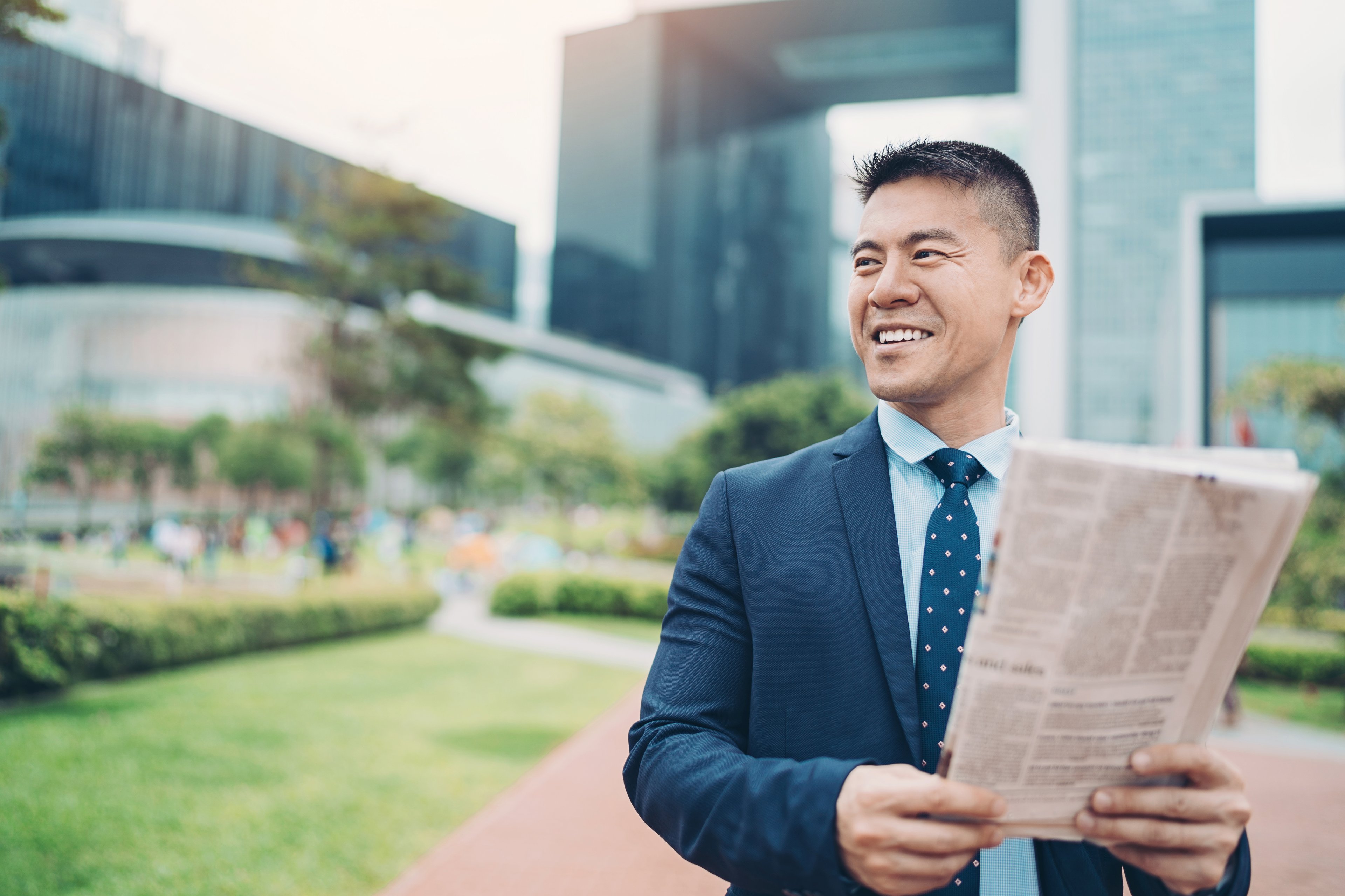 business newspaper suit outside happy