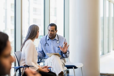 doctor talks to patient in ward hallway