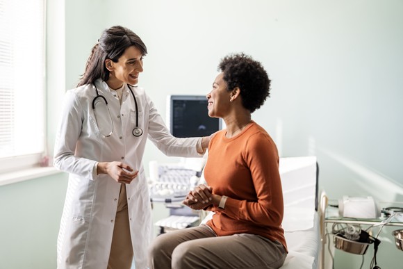 A health professional consoles a patient. 