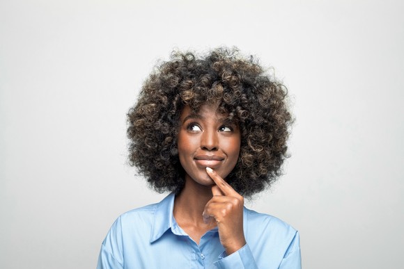 Someone with their finger on their chin looking as if they're thinking deeply.