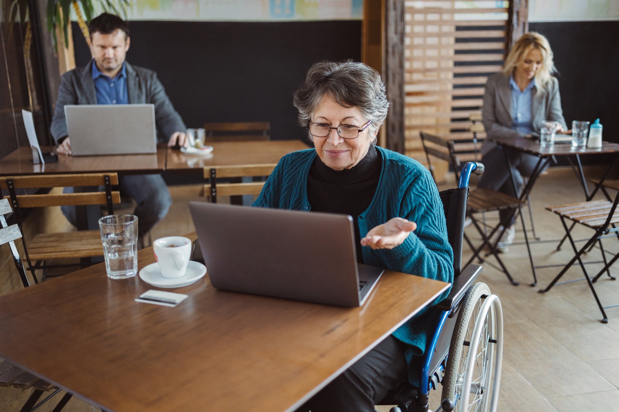 Person sitting in a cafeteria and looking at a computer.