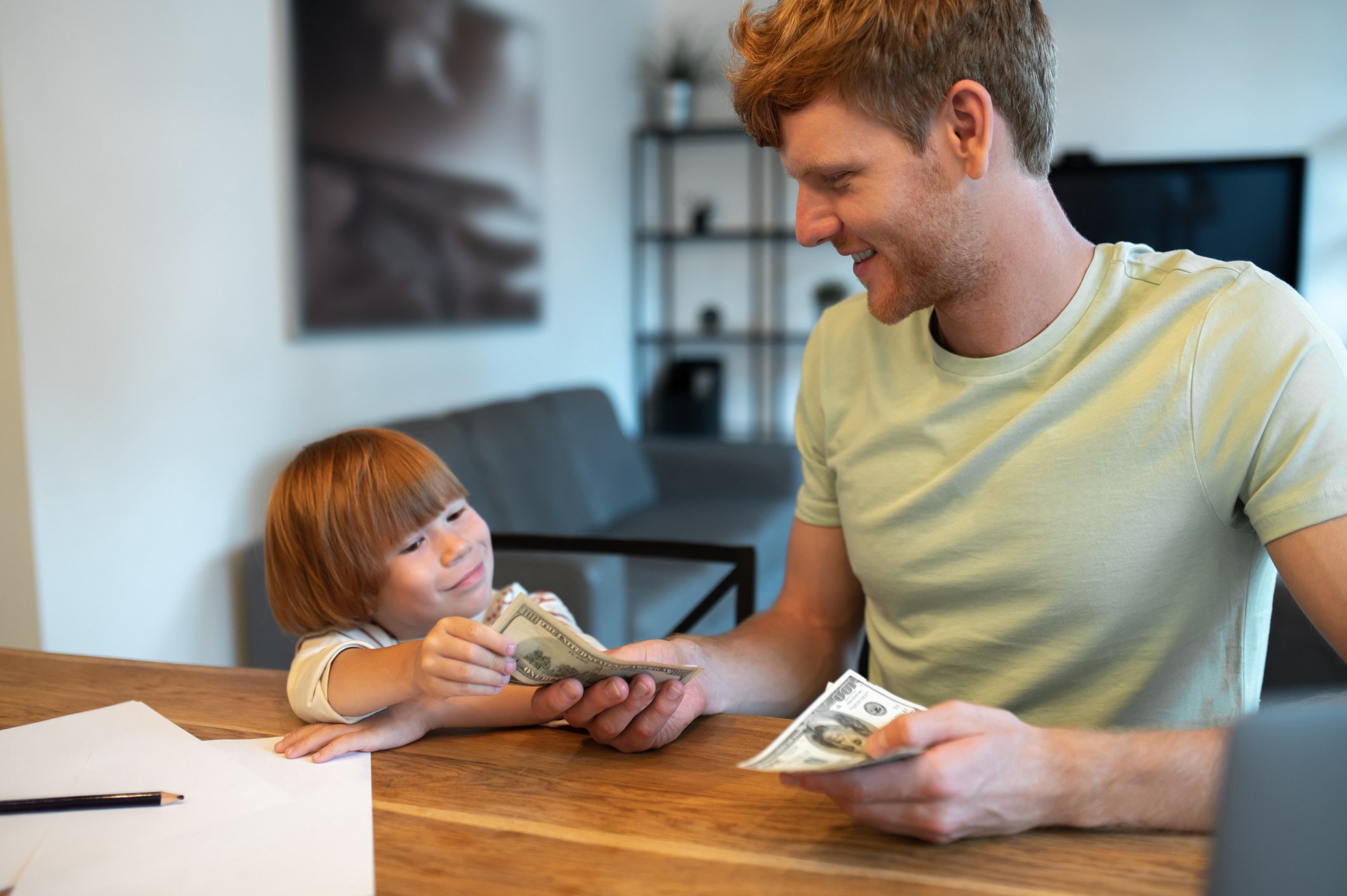 An adult handing a child some cash.