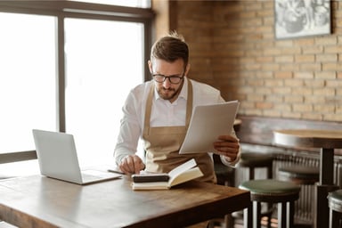 Person at table with pen and computer
