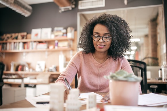 A person sitting at a table and looking at paperwork.