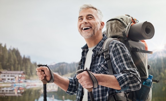 A smiling person backpacking.