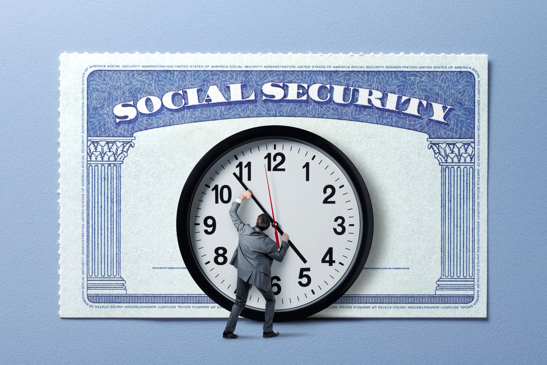 Person pushing the hands of a clock overlaid on a Social Security card.