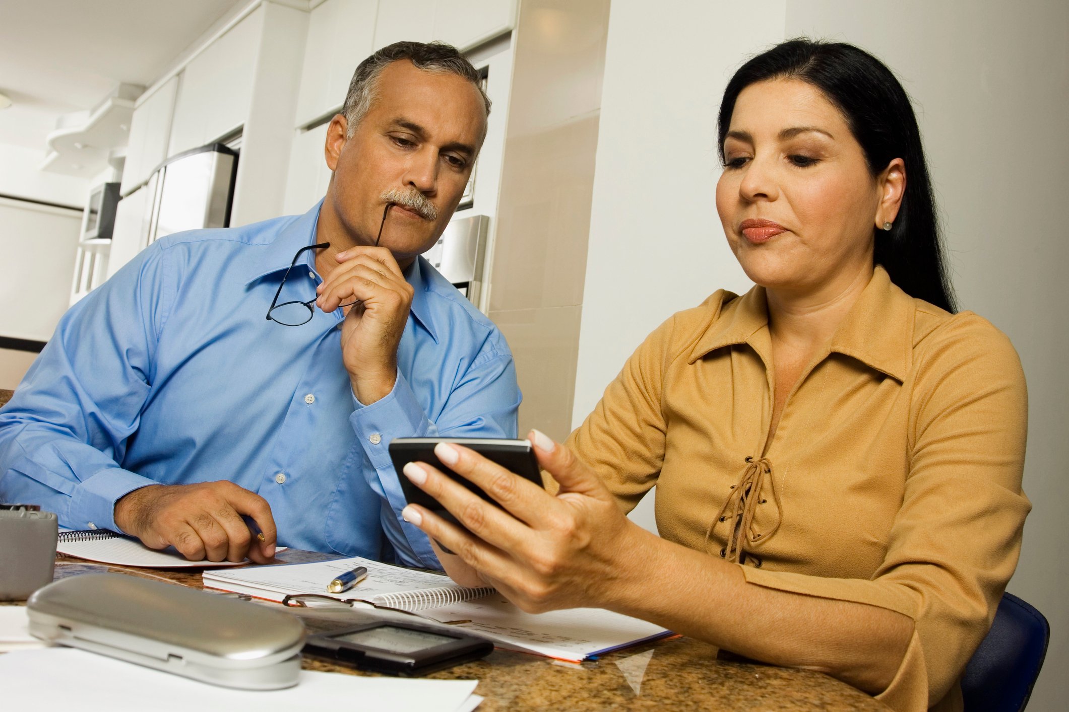 Two people looking at a calculator.