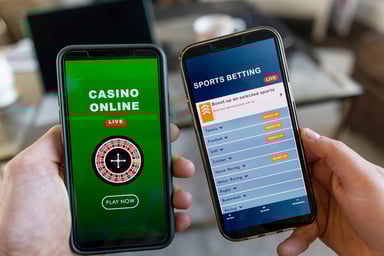 Two hands holding phones open to gambling sites.