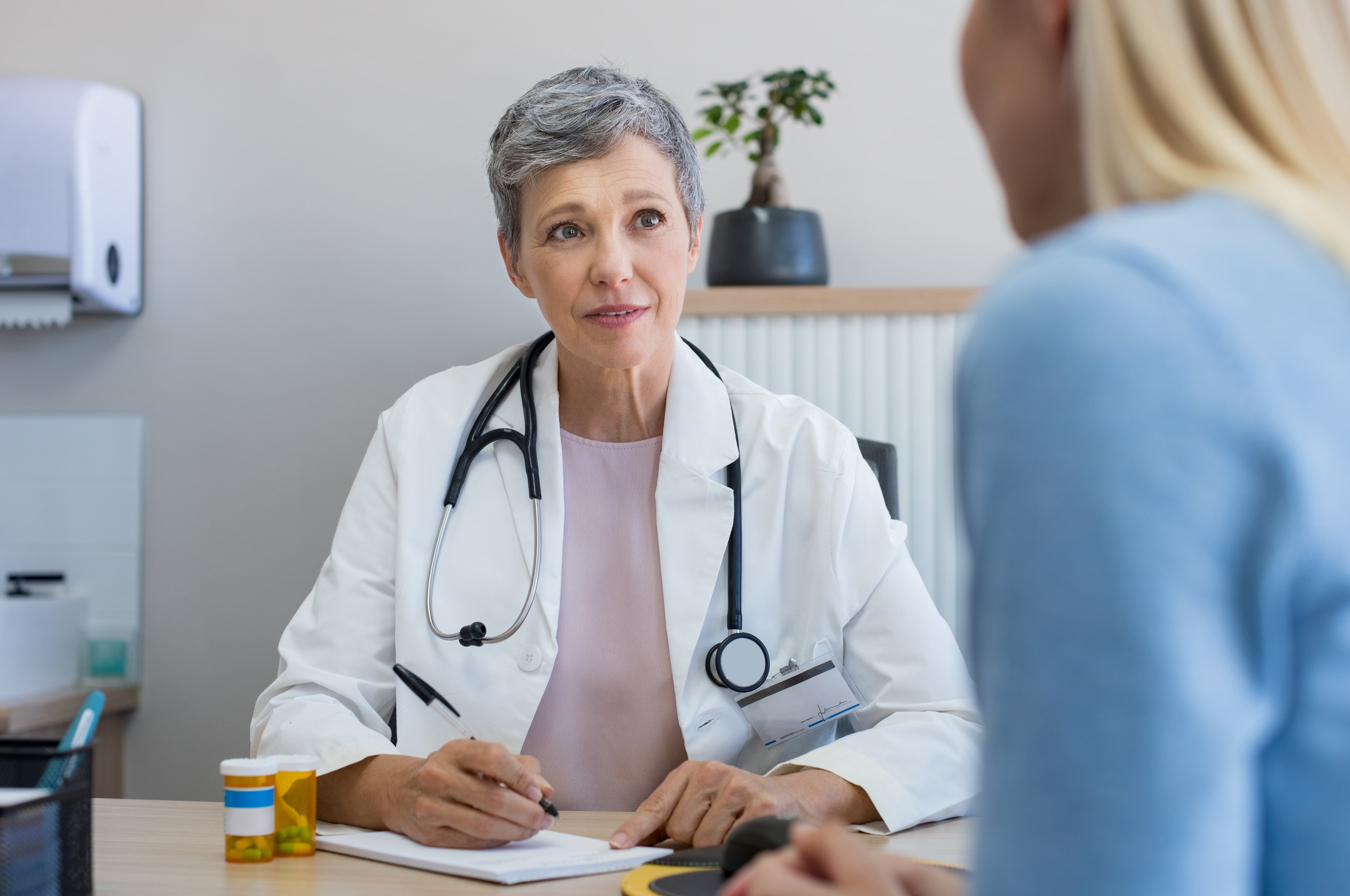 A doctor writing a prescription for a patient.