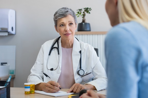 A doctor writing a prescription for a patient.