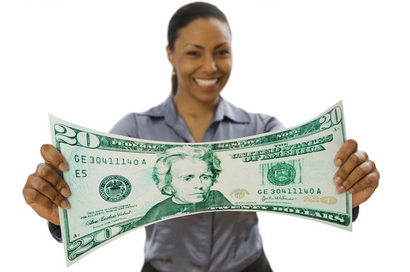 Smiling person holding a large $20 bill.