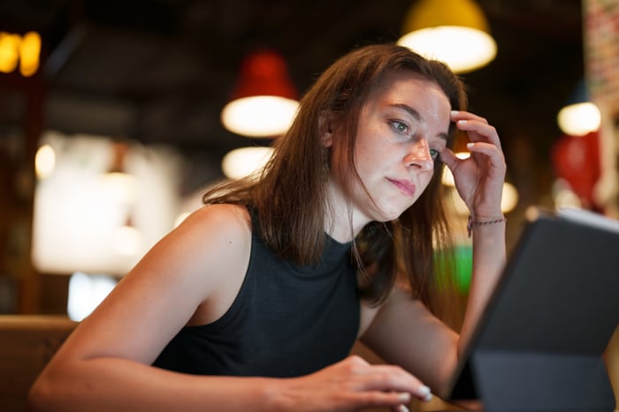 A person looking at a digital tablet.