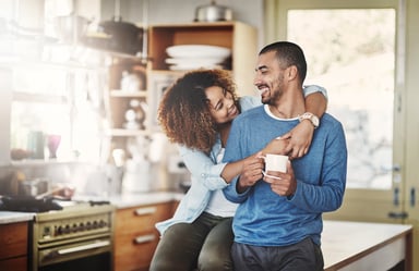 Two people drinking coffee in a kitchen