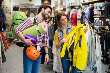 Couple buying gear in sporting goods store.