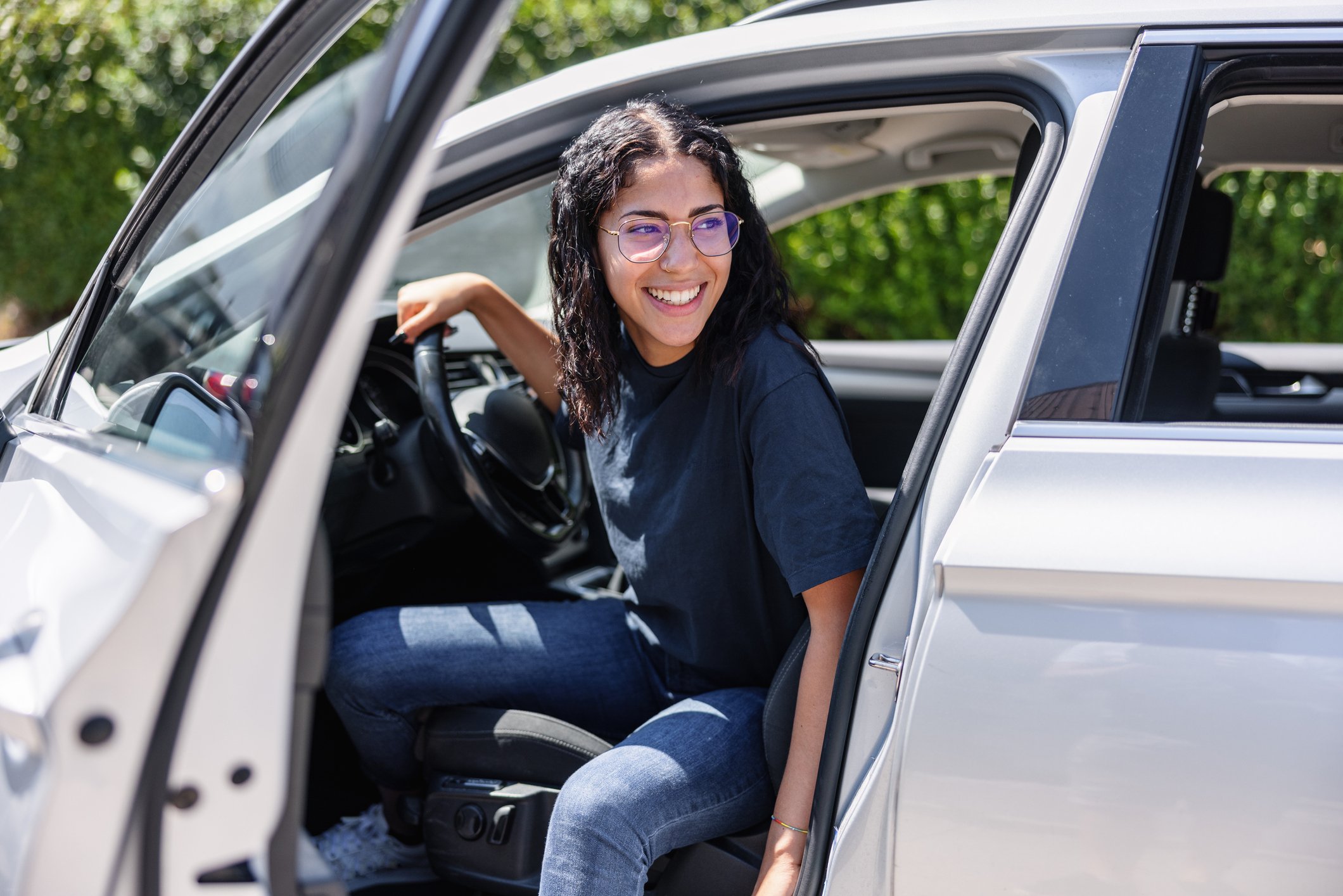 Person getting out of car, smiling.