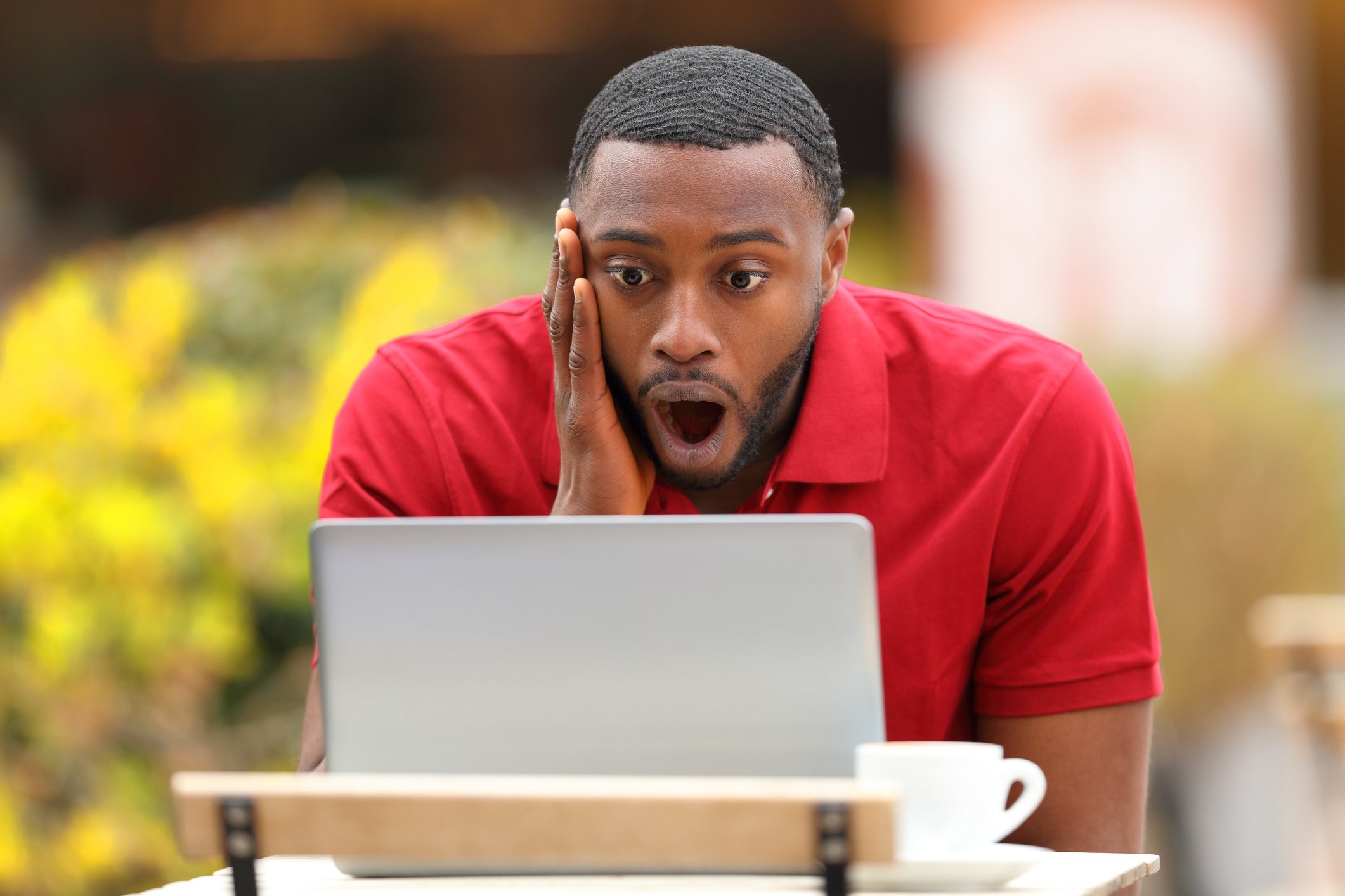 Person looking at laptop screen with surprised facial expression.