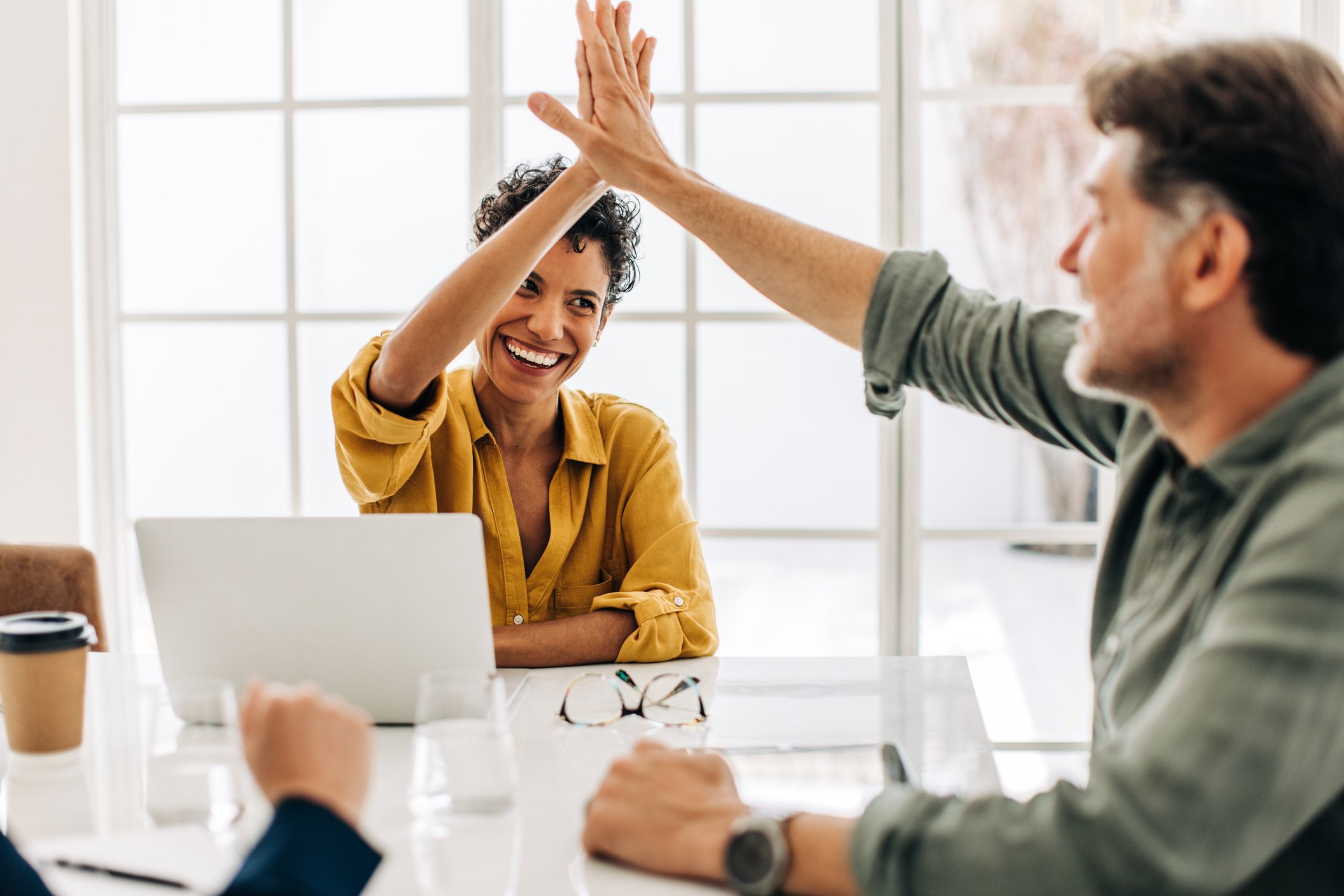 Two people high-fiving in an office.