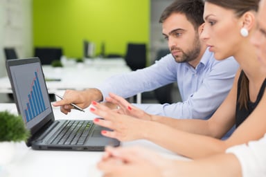 People looking at a chart on a laptop.